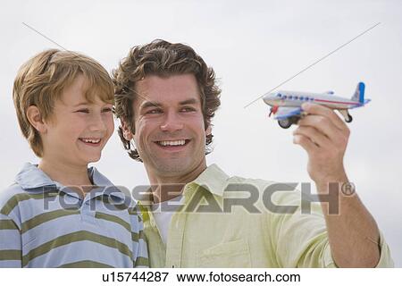 Father and son playing with toy airplane View Large Photo Image Stock Photo - Father and son playing with toy airplane. Fotosearch