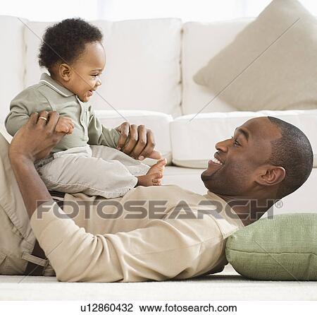 Father playing with baby on floor View Large Photo Image Stock Image - Father playing with baby on floor. Fotosearch