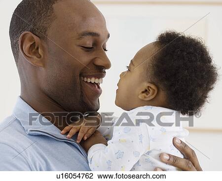 Stock Image - Father smiling at baby. Fotosearch