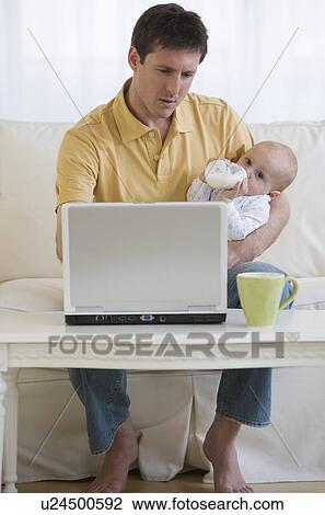 Father using laptop and feeding baby View Large Photo Image Stock Image - Father using laptop and feeding baby. Fotosearch