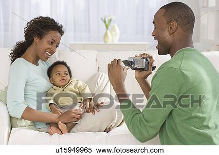 Father video recording mother and baby on sofa View Large Photo Image Stock Photography - Father video recording mother and baby on sofa. Fotosearch