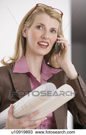 Stock Image - Female architect talking on cell phone. Fotosearch