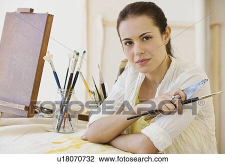 Stock Image - Female artist in painting studio. Fotosearch