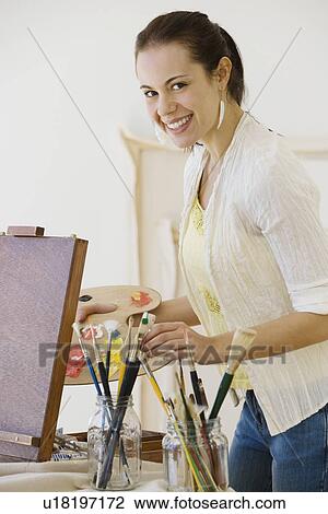 Stock Image - Female artist in painting studio. Fotosearch