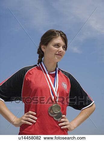 Stock Image - Female athlete with medals around neck. Fotosearch