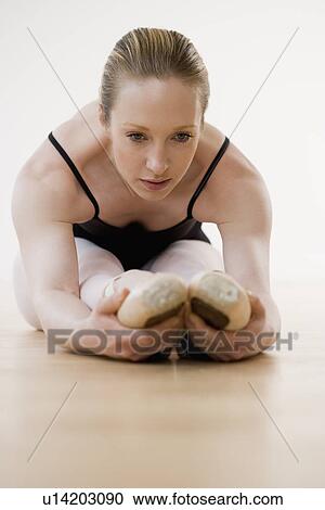 Female ballet dancer stretching on floor View Large Photo Image Stock Image - Female ballet dancer stretching on floor. Fotosearch