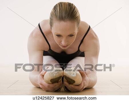 Female ballet dancer stretching on floor View Large Photo Image Stock Photo - Female ballet dancer stretching on floor. Fotosearch