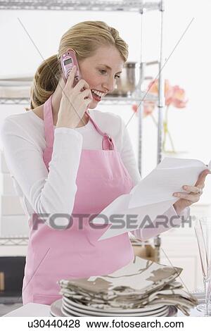Stock Photo - Female caterer talking on cell phone. Fotosearch