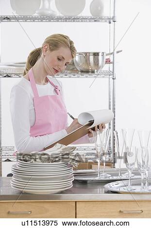 Female caterer writing on clipboard View Large Photo Image Stock Photography - Female caterer writing on clipboard. Fotosearch