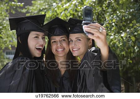 Female college graduates taking own photograph View Large Photo Image Stock Photograph - Female college graduates taking own photograph. Fotosearch