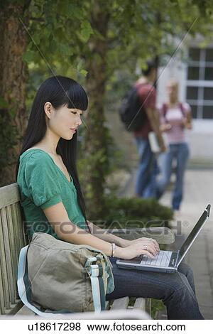 Stock Photo - Female college student typing on laptop. Fotosearch