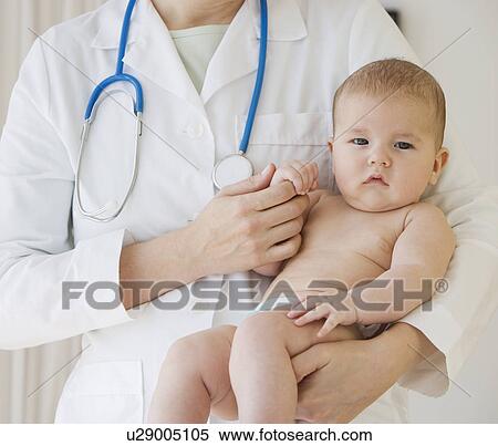Stock Photography - Female doctor holding baby. Fotosearch