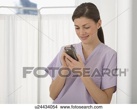 Picture - Female doctor looking at electronic organizer. Fotosearch
