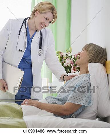 Female doctor talking to senior woman in hospital bed View Large Photo Image Stock Photograph - Female doctor talking to senior woman in hospital bed. Fotosearch