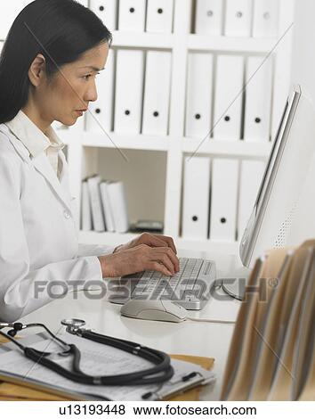 Stock Photo - Female doctor using computer. Fotosearch