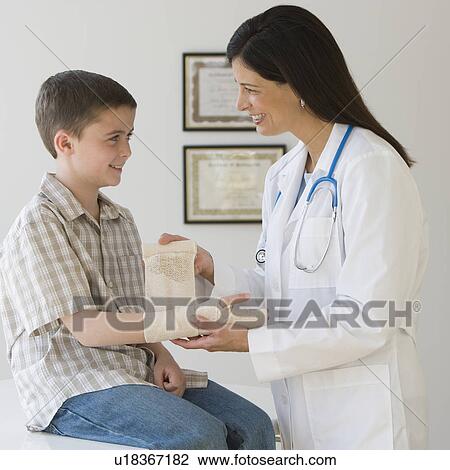 Female doctor wrapping boy’s wrist View Large Photo Image Stock Image - Female doctor wrapping boy’s wrist. Fotosearch