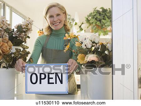 Female florist hanging Open sign in window View Large Photo Image Stock Image - Female florist hanging Open sign in window. Fotosearch