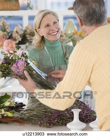 Female florist helping customer View Large Photo Image Stock Image - Female florist helping customer. Fotosearch