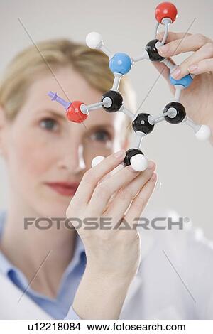 Picture - Female scientist looking at molecule model. Fotosearch