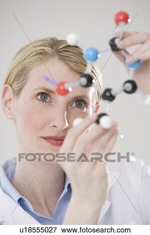 Stock Photo - Female scientist looking at molecule model. Fotosearch