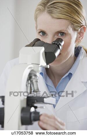 Female scientist looking into microscope View Large Photo Image Stock Photo - Female scientist looking into microscope. Fotosearch