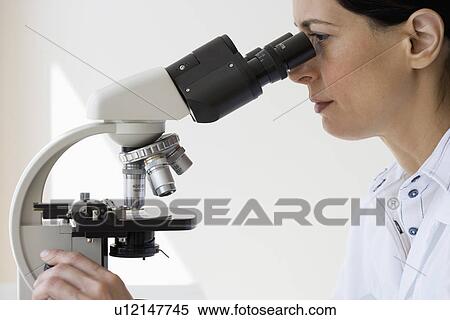 Female scientist looking into microscope View Large Photo Image Stock Photography - Female scientist looking into microscope. Fotosearch