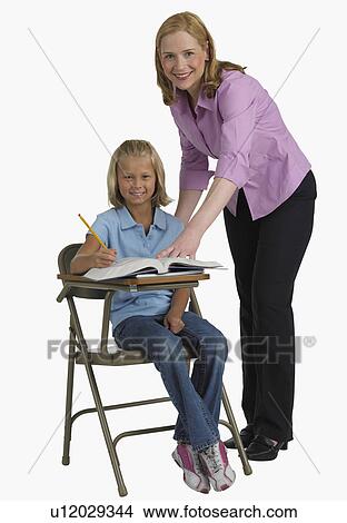 Female teacher helping student at desk View Large Photo Image Picture - Female teacher helping student at desk. Fotosearch