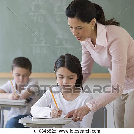 Stock Photography - Female teacher helping student. Fotosearch