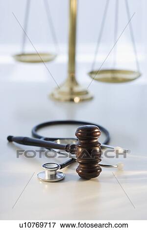 Stock Photo - Gavel on stethoscope with scales in background. Fotosearch