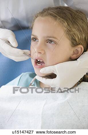 Stock Photo - Girl being examined by dentist. Fotosearch