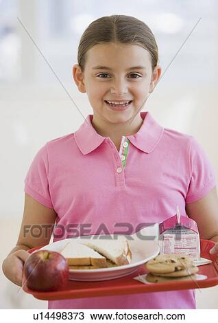 Stock Image - Girl carrying lunch tray. Fotosearch