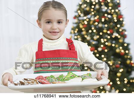 Girl carrying tray of Christmas cookies View Large Photo Image Stock Image - Girl carrying tray of Christmas cookies. Fotosearch