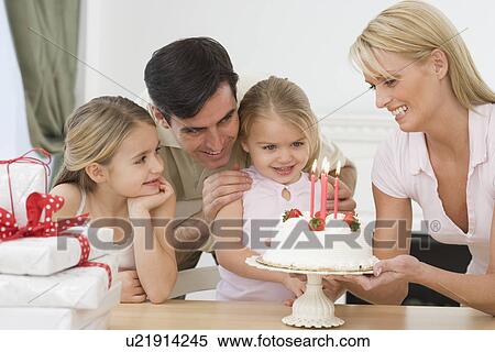 Stock Photography - Girl celebrating birthday with family. Fotosearch