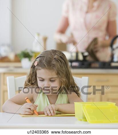 Stock Photography - Girl coloring at kitchen table. Fotosearch