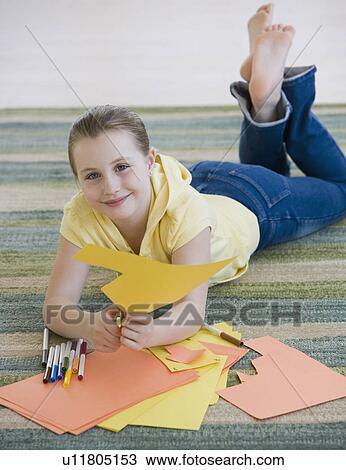 Girl cutting construction paper on floor View Large Photo Image Stock Image - Girl cutting construction paper on floor. Fotosearch
