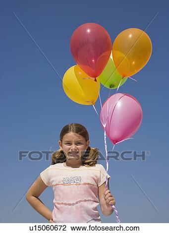 Stock Image - Girl holding balloons. Fotosearch