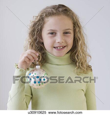 Stock Photography - Girl holding Christmas ornament. Fotosearch