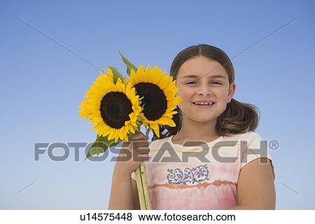 Girl holding sunflowers View Large Photo Image Stock Photo - Girl holding sunflowers. Fotosearch