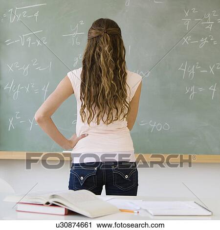 Stock Image - Girl looking at blackboard. Fotosearch