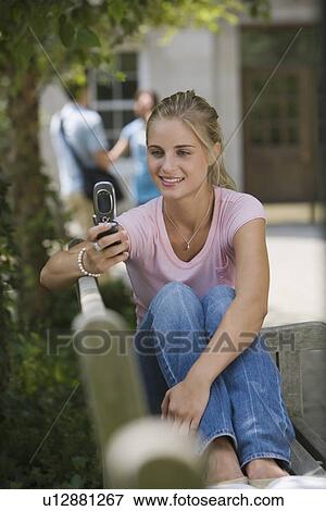 Stock Photo - Girl looking at cell phone. Fotosearch