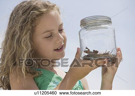 Girl looking at reptile in jar View Large Photo Image Stock Image - Girl looking at reptile in jar. Fotosearch