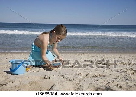 Girl playing in sand View Large Photo Image Picture - Girl playing in sand. Fotosearch