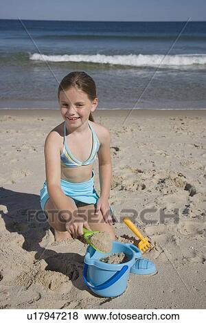 Girl playing in sand View Large Photo Image Stock Photo - Girl playing in sand. Fotosearch