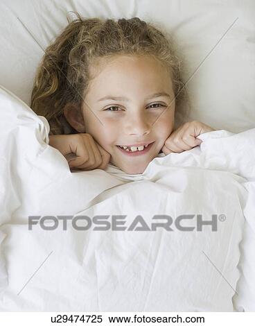 Girl pulling blanket up to chin View Large Photo Image Stock Photography - Girl pulling blanket up to chin. Fotosearch