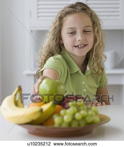Girl reaching for fruit in bowl View Large Photo Image Stock Image - Girl reaching for fruit in bowl. Fotosearch
