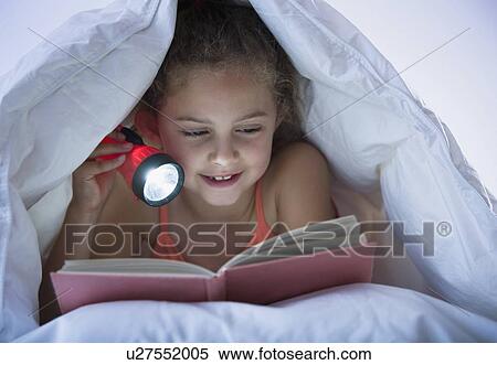 Girl reading with flashlight under blanket View Large Photo Image Stock Photography - Girl reading with flashlight under blanket. Fotosearch