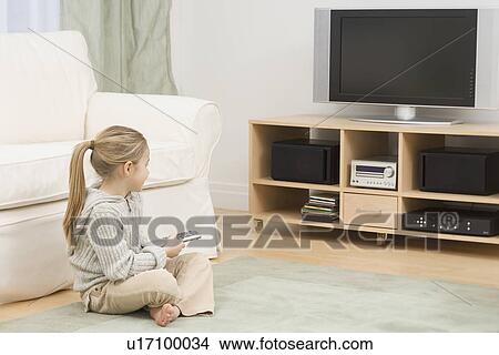 Girl sitting on floor watching television View Large Photo Image Picture - Girl sitting on floor watching television. Fotosearch