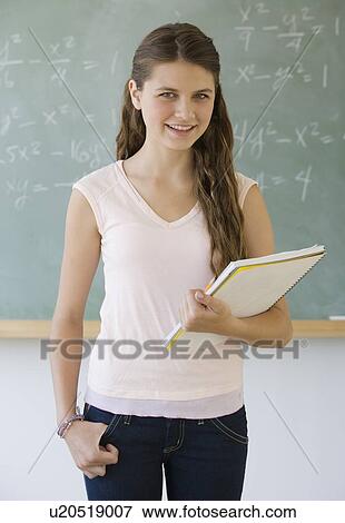 Stock Photo - Girl standing in front of blackboard. Fotosearch