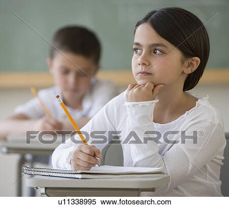 Girl thinking at desk in classroom View Large Photo Image Stock Photography - Girl thinking at desk in classroom. Fotosearch