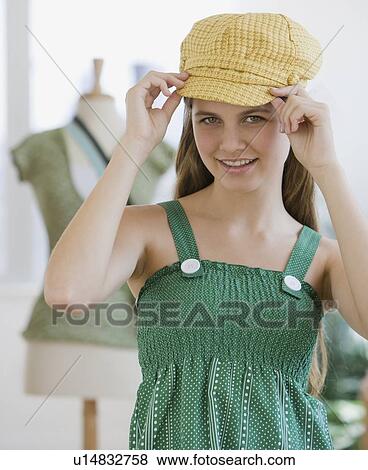 Stock Photo - Girl trying on hat. Fotosearch
